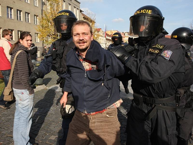 Policisté zadržují jednoho z účastníků nepovolené demonstrace.