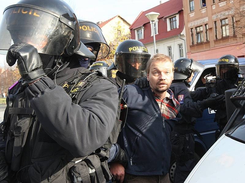 Policisté zadržují jednoho z účastníků nepovolené demonstrace.