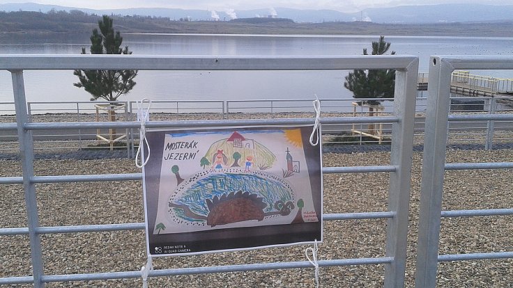 Výstava obrázků dětí "Po stopách jezerní příšery" na pláži jezera Most.
