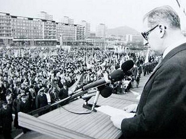 Na snímku z roku 1987 je manifestace k 55. výročí Velké mostecké stávky. Projev čte předseda komunistické vlády Lubomír Štrougal. Tomuto místu se říkalo Plecháč, dnes tu stojí obchodní dům Central.