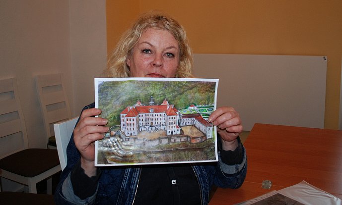 Kastelánka Jezeří Hana Krejčová ukazuje obrazovou rekonstrukci barokního zámku a jeho nejbližšího okolí v době největší slávy tohoto knížecího komplexu.