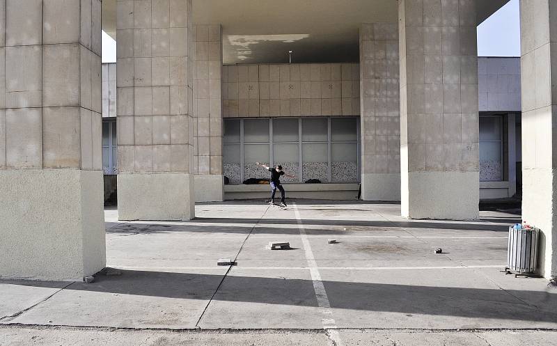 Chlapec na skateboardu mezi sloupy hotelu Cascade v centru Mostu