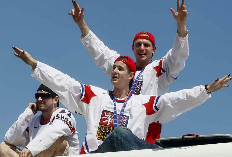 Čeští hokejisté Roman Červenka (uprostřed) a Petr Vampola (vpravo) zdraví 24. května v Praze fanoušky po příletu z dějiště mistrovství světa v ledním hokeji v Německu, kde vybojovali zlaté medaile.