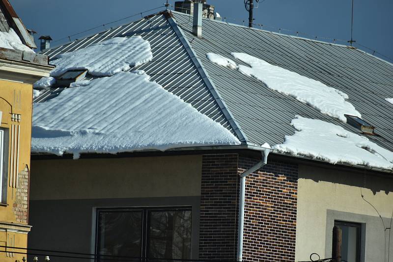 Tající sníh na střechách v Teplicích.