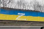 Někdo přes dvacetimetrovou ukrajinskou vlajku namalovanou barvou na protihlukové zdi na silnici u stadionu v Teplicích vytvořil bílou barvou symbol písmene "Z".
