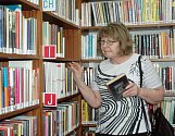 Olga Somolová vybírá knížky v Regionální knihovně Teplice.