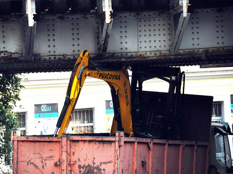 V Teplicích pod železničním mostem ve Spojenecké ulici (z ulice Na Hrázi propojka na Nákladní) uvízlo v pondělí ráno nákladní auto s naloženým bagrem.