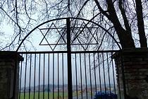 Pohled ze židovského hřbitova skrz hlavní, pro vstup nepoužívanou bránu na Poběžovice.