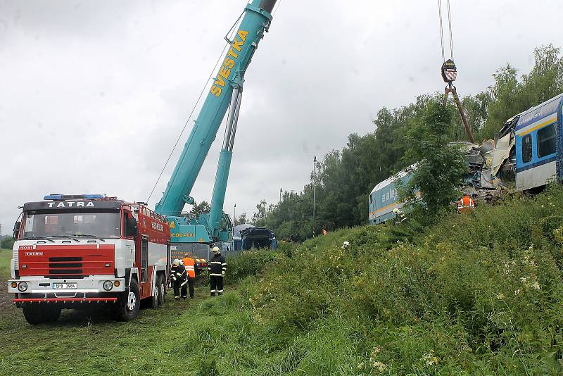 Jeřáb nejdříve odstranil zdevastovaný vagon rychlíku a snesl ho pod násep, pak dostal lokomotivu i celou soupravu osobního vlaku zpátky na koleje.