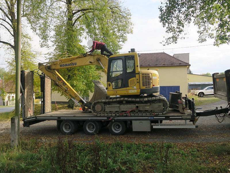 Při převozu bagru řidič neodhadl výšku nákladu, výsledkem bylo poškození konstrukce železničního přejezdu.