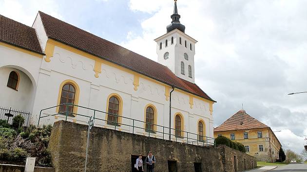 Kostel svatého Jiřího v Koutě na Šumavě stojí na pivovarských sklepech. U vchodu do podzemních chodeb stojí Anna Váchalová a starosta obce Bohuš Havlovic.