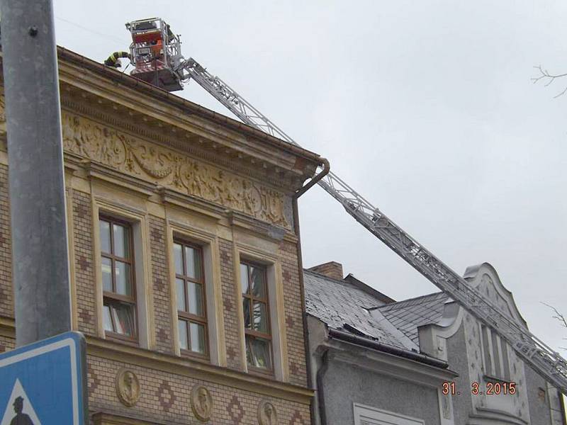 Hasiči ve Kdyni zajišťují střechu základní školy na náměstí.