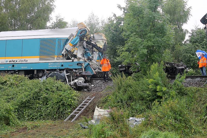 Jeřáb nejdříve odstranil zdevastovaný vagon rychlíku a snesl ho pod násep, pak dostal lokomotivu i celou soupravu osobního vlaku zpátky na koleje.