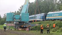 Jeřáb nejdříve odstranil zdevastovaný vagon rychlíku a snesl ho pod násep, pak dostal lokomotivu i celou soupravu osobního vlaku zpátky na koleje.