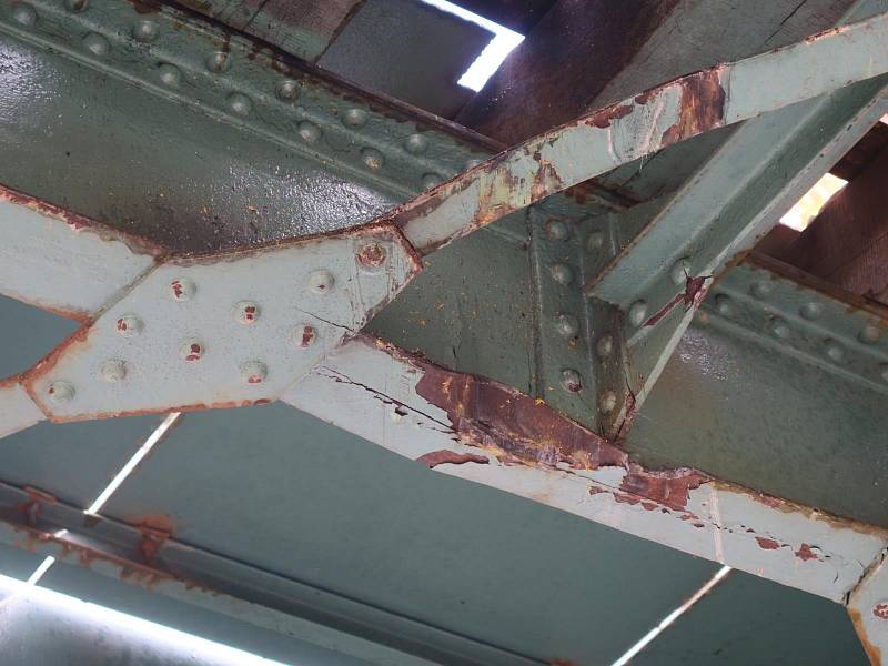 Při převozu bagru řidič neodhadl výšku nákladu, výsledkem bylo poškození konstrukce železničního přejezdu.