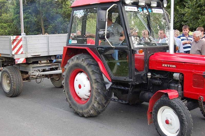Závod v couvání traktoru s vlekem okolo návsi v Libkově.