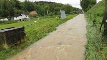 Za střídačkami u fotbalového hřiště v Hostouni déšť proměnil cestu v řeku. Snímek je ze sobotního odpoledne, kdy hladina téhle ´říčky´ podle místních zahrádkářů opadla o 60 cm.