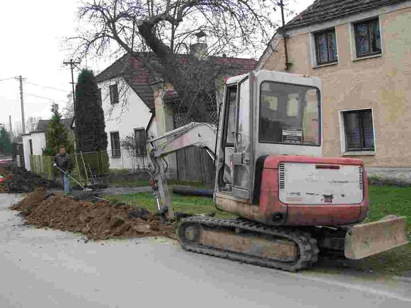 Sobotní den na stavbě v Havlovicích., I když tudy mohou projíždět pouze linkové autobusy a případně auta Havlovických, není tomu vždy tak a dělníci musejí se stroji uhýbat.