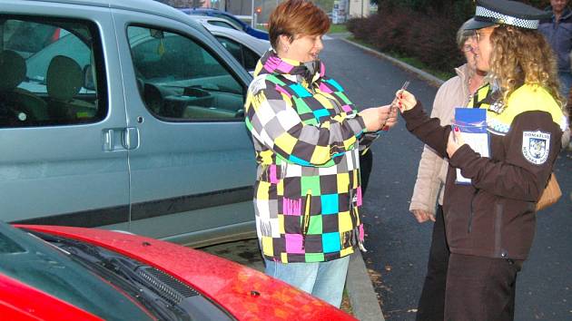 Strážníci řidiče informují o změně parkovacího systému v ulici E. Krásnohorské. Zároveň jim věnují i parkovací hodiny. 