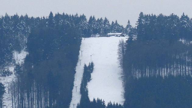 SJEZDOVKA NA SÁDKU ze silnice Ždánov-Pařezov. Svou výraznou bělostí v kontrastu s ostatní krajinou klame, neboť lyžovat se tam nedá.