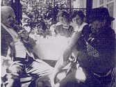 Spisovatel Alois Jirásek na návštěvě u malíře Karla Špillara v Peci pod Čerchovem. Na fotografii sedí Jirásek vlevo, zcela vzadu pak paní Berta Špillarová. Snímek pořídil malíř Karel Špillar na verandě „Špillarovny“. Fotografie nebyla datována. 