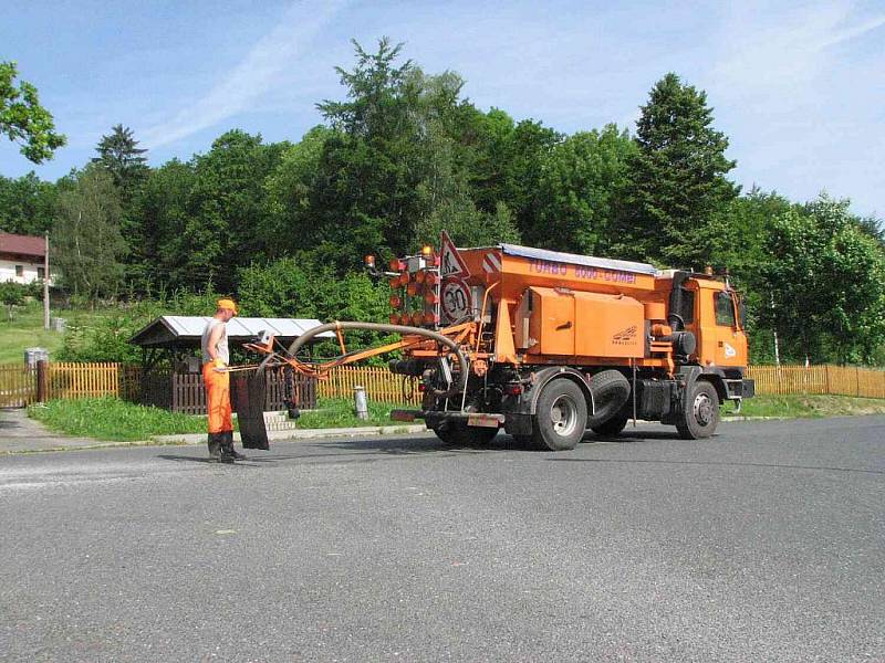 Zatímco někde se výtluky opravují balenou směsí, jinde postačí ošetřit vozovku takto postřikem s přídavkem šotoliny. Souprava nazvaná Turbo 5000 combi pojme pět kubíků kameniva a 1,2 metru kubického emulze, kterou zahřívá speciální hořák. 