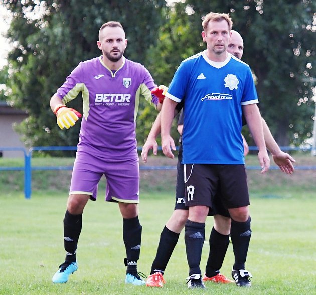 Gólman Michal Šteyr se v zápasech III. třídy Královéhradecka potkává i s exligovým Michalem Lesákem (v modrém), hráčem Dobřenic.