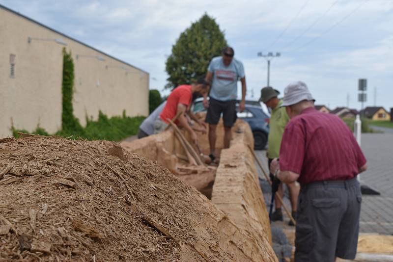 Jedenáctimetrový člun vytesávají dobrovolníci u archeoparku ve Všestarech. Příští rok se vydá na moře.