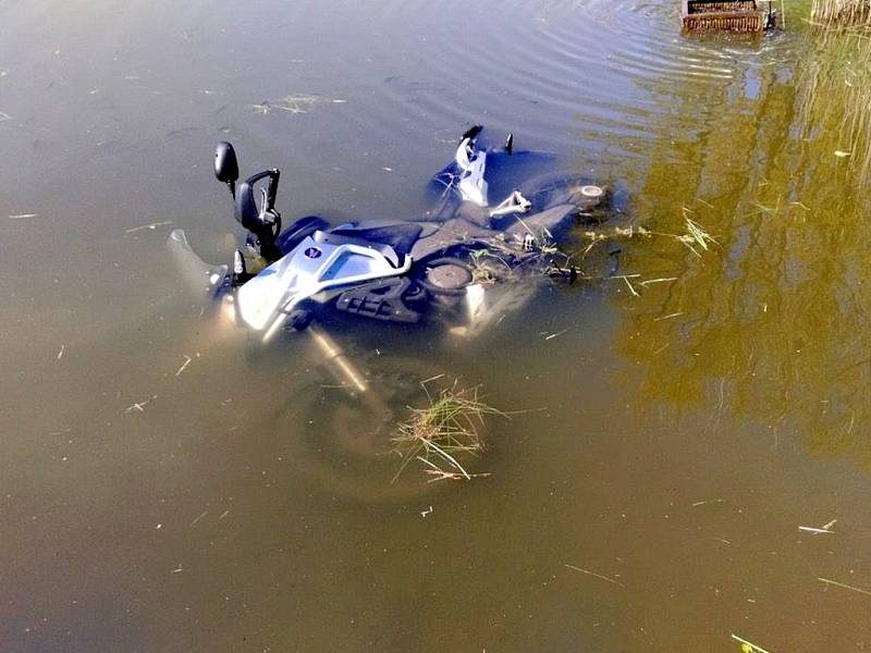 Motocykl v rybníku po srážce s osobním automobilem.