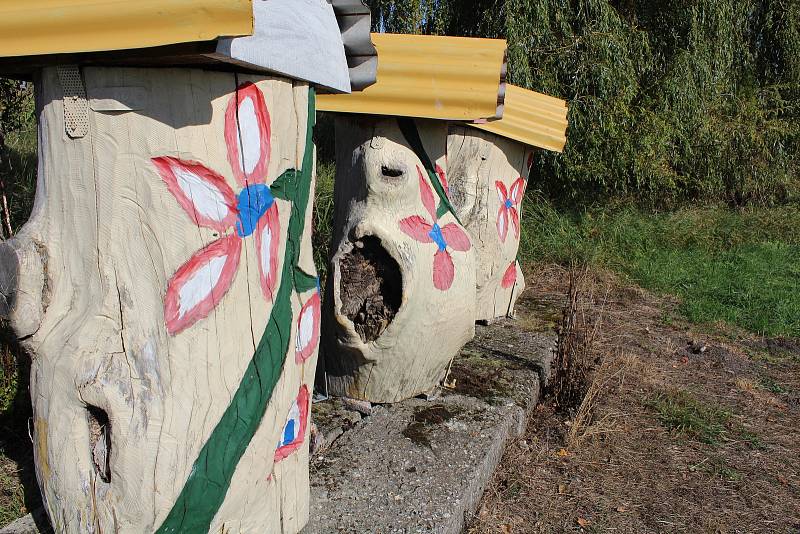 Z volně přístupné zahrady plné nejen malovaných "úlů", ale i květin, motýlů, ptačích budek a najdete tu i pozoruhodný "sad".