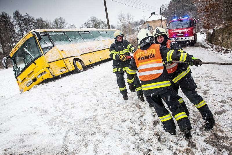 Sněhová kalamita na Královérahdecku. Zapadlý autobus hrozil pádem v obci Dolní Rybníky na Náchodsku z kopce museli ho vyprostit hasiči.