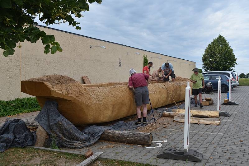 Jedenáctimetrový člun vytesávají dobrovolníci u archeoparku ve Všestarech. Příští rok se vydá na moře.