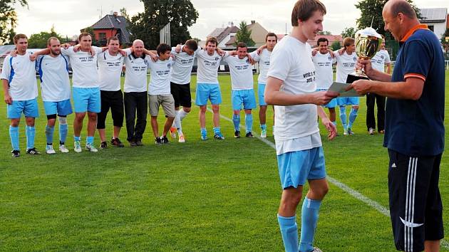 Radek Michlík, kapitán Sokola Třebeš B, se spoluhráči při předání poháru pro vítěze III. třídy od Vladana Haleše, místopředsedy Okresního fotbalového svazu Hradec Králové.