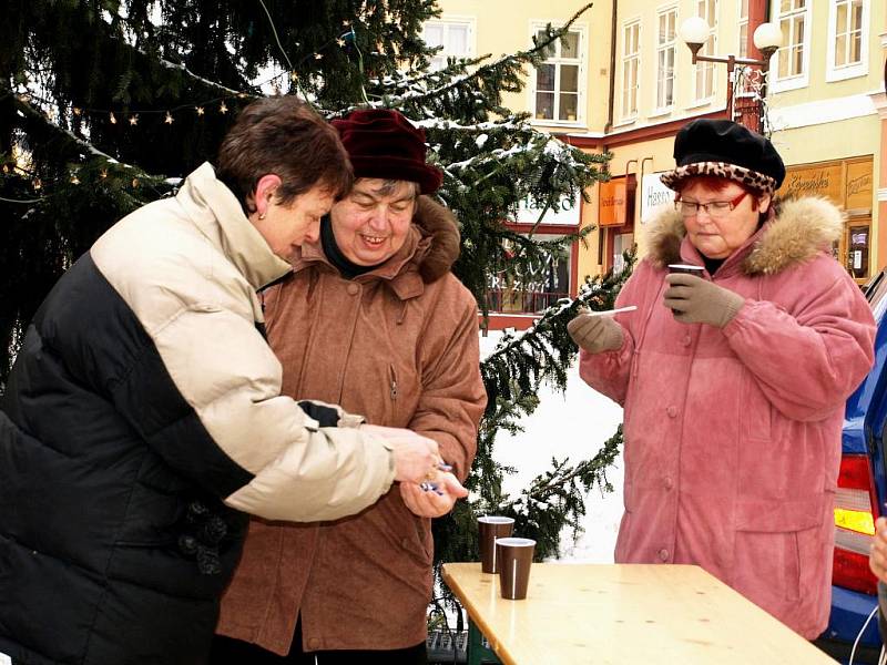 KOLEDNÍCI při 'starostově' polévce na chebském náměstí zpívali koledy. Na kytaru je doprovázel farář Petr Hruška. 