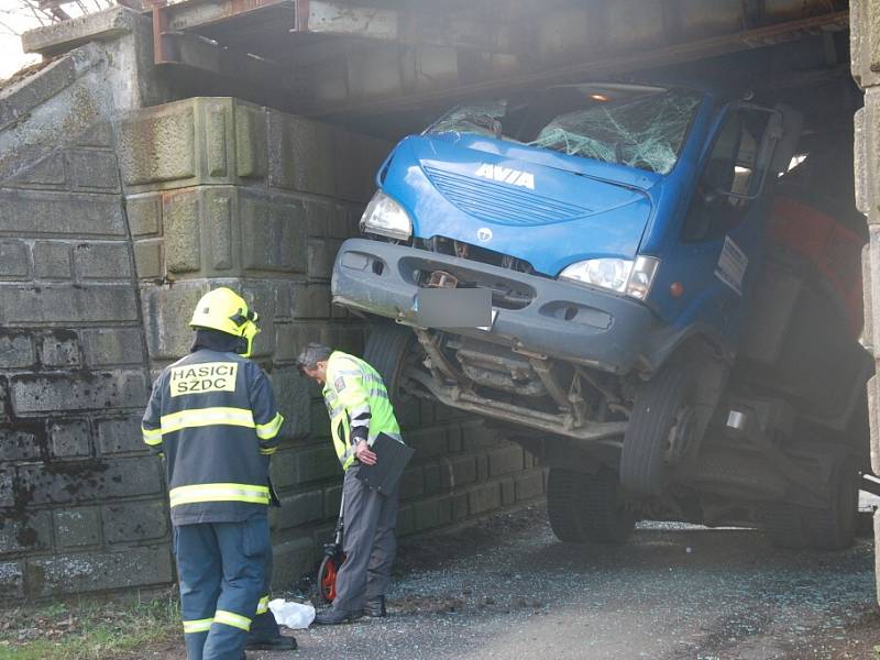 Nepříjemné překvapení čekalo včera na řidiče nákladního vozidla při projíždění pod železničním viaduktem v Nebanicích na Chebsku. Šofér si totiž neuvědomil, že na korbě veze bagr, který je příliš vysoký na to, aby pod viaduktem projel. 