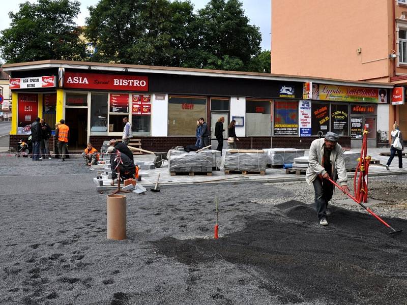 Rekonstrukce I. části pěší zóny v Chebu. Dlaždiči už položili část nové dlažby od křižovatky s Evropskou ulicí. Na portější straně likvidují stavební dělníci zasypané základy bývalých veřejných záchodků.