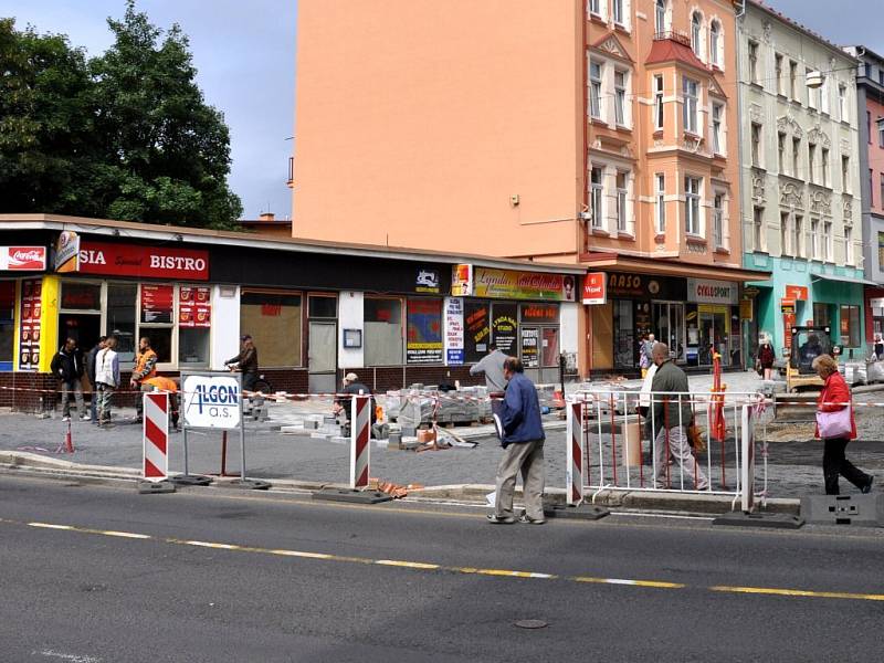 Rekonstrukce I. části pěší zóny v Chebu. Dlaždiči už položili část nové dlažby od křižovatky s Evropskou ulicí. Na portější straně likvidují stavební dělníci zasypané základy bývalých veřejných záchodků.