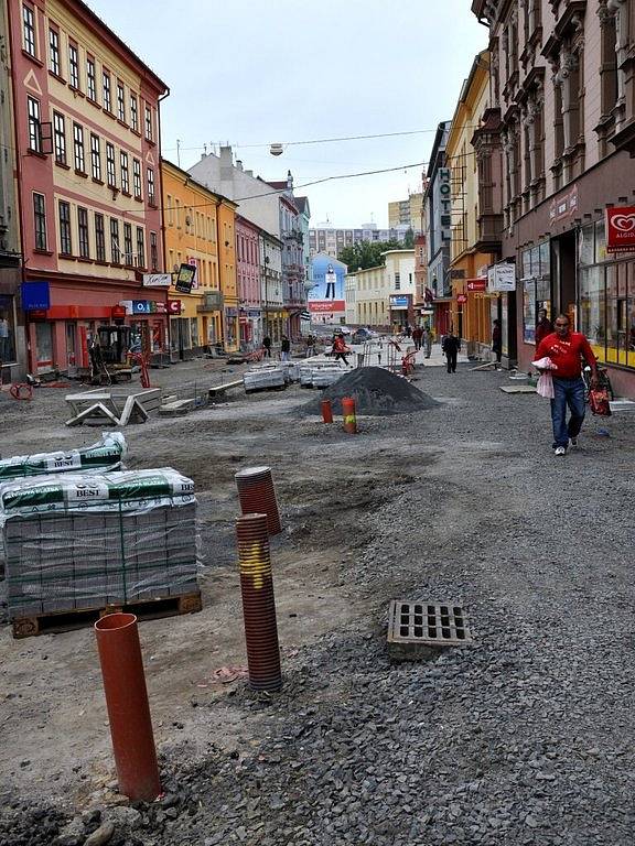 Rekonstrukce I. části pěší zóny v Chebu. Dlaždiči už položili část nové dlažby od křižovatky s Evropskou ulicí. Na portější straně likvidují stavební dělníci zasypané základy bývalých veřejných záchodků.