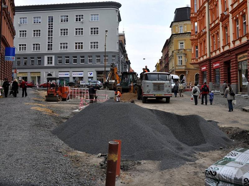 Rekonstrukce I. části pěší zóny v Chebu. Dlaždiči už položili část nové dlažby od křižovatky s Evropskou ulicí. Na portější straně likvidují stavební dělníci zasypané základy bývalých veřejných záchodků.