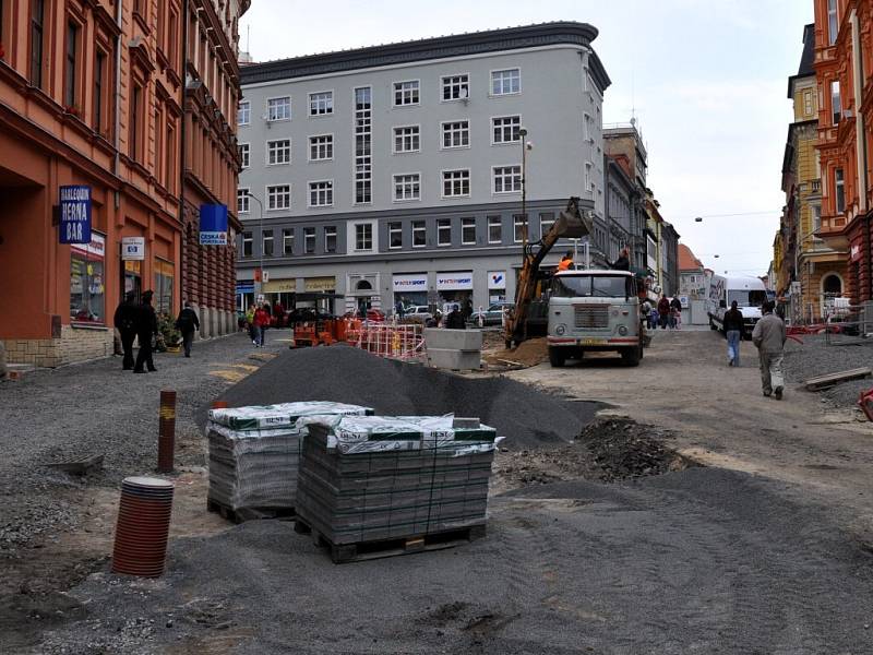 Rekonstrukce I. části pěší zóny v Chebu. Dlaždiči už položili část nové dlažby od křižovatky s Evropskou ulicí. Na portější straně likvidují stavební dělníci zasypané základy bývalých veřejných záchodků.