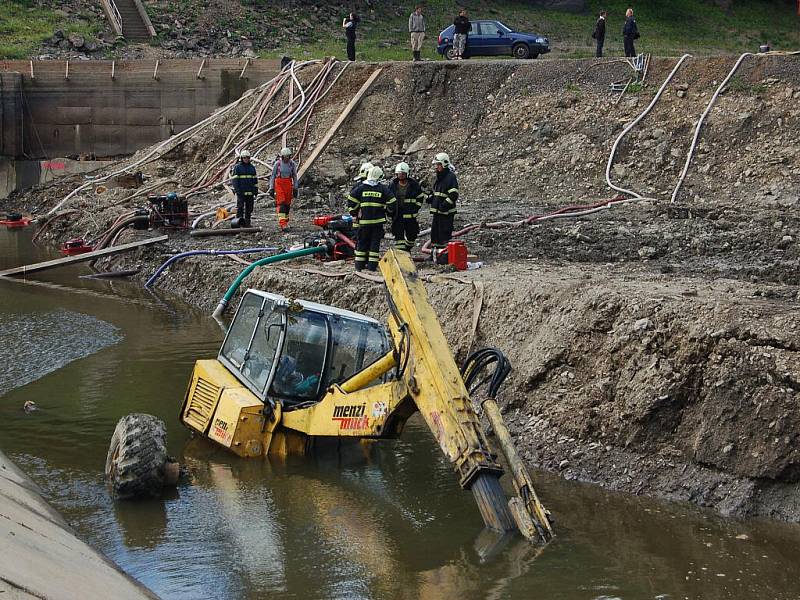 POTOPENÝ BAGR na chebské přehradě Skalka zaměstnal na několik hodin jednotky hasičů, které pomocí čerpadel stroj vysvobodily.   