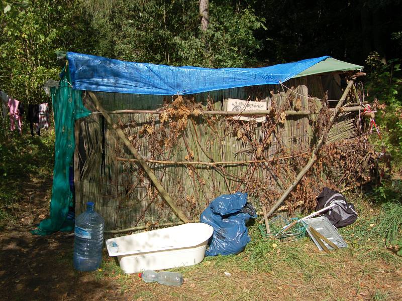 Nedaleko vodní nádrže Skalka v Chebu si několik lidí postavilo příbytky ze stanů a různých kousků dřeva. Dokonce zde mají vanu a láhve na pitnou vodu. 