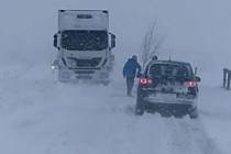 V závějích sněhu u Kramolína uvízly dva kamiony a dalších šestnáct aut.