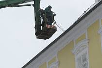 Sníh ze střech historických domů na chebském náměstí Krále Jiřího z Poděbrad museli pracovníci technických služeb odstraňovat pomocí vysokozdvižné plošiny