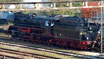 Parní lokomotiva řady 41 DR při průjezdu pod lávkou pro pěší na chebském nádraží