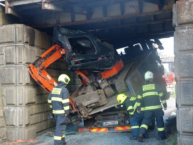 Nepříjemné překvapení čekalo včera na řidiče nákladního vozidla při projíždění pod železničním viaduktem v Nebanicích na Chebsku. Šofér si totiž neuvědomil, že na korbě veze bagr, který je příliš vysoký na to, aby pod viaduktem projel. 