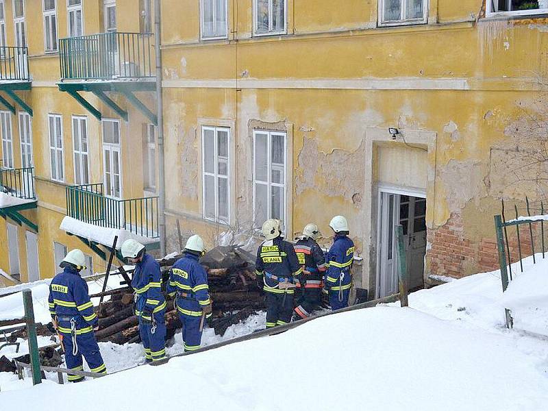 Uskladněné dříví hořelo v jednom z mariánskolázeňských domů. Hasiči museli požár uhasit v maskách. 