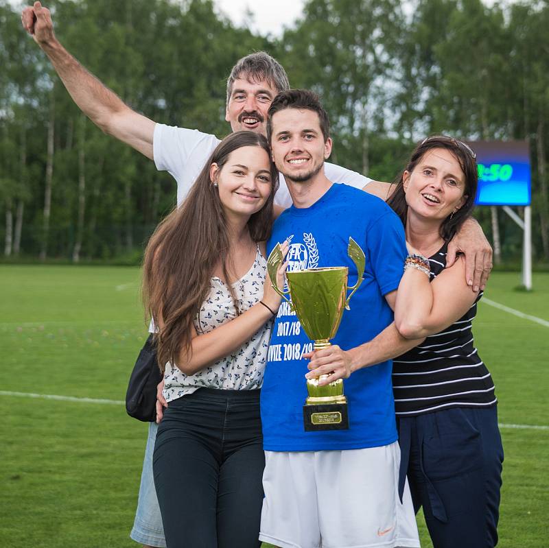 Ostrovští fotbalisté (v modrém) slavili po utkání s Královským Poříčím, které vyhráli 7:1, návrat do divizní soutěže.