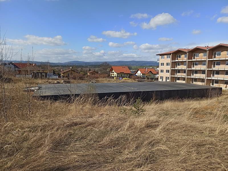 Čtyřpodlažní dům v Jenišově je vidět zdaleka, stal se nechtěným vředem obce. Areál zarostl, oplocení se rozpadá.