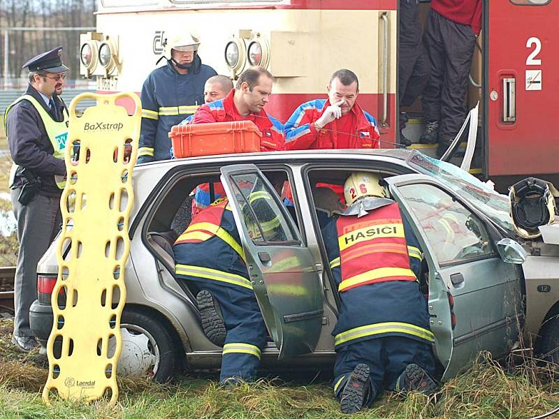 Záchranáři ošetřují řidiče, který nezastavil před přejezdem v Nové Roli a srazil se tak s motorovým vlakem.